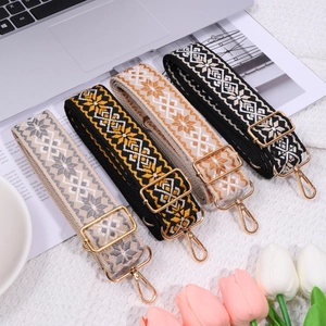 Detail of colorful woven shoulder straps with geometric patterns and gold metal buckles