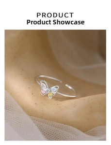 Close-up of silver butterfly ring featuring colorful crystals on a soft beige background