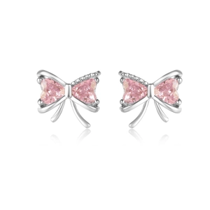 Close-up of S925 silver bow earrings featuring polished pink heart-shaped crystals