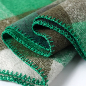 Detail showing green and brown plaid cashmere-like fabric with green stitching