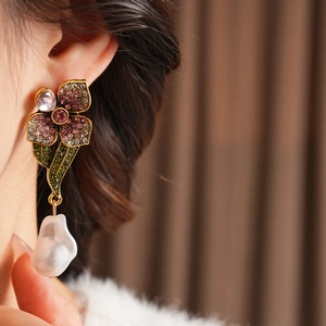 Gros plan de boucles d'oreilles vintage avec cristaux colorés et perles baroques