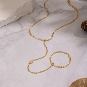 Elegante cavigliera a catena in acciaio dorato con zircone su superficie in marmo bianco