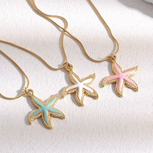 Detailed view of 18K gold plated starfish necklaces in blue, white and pink enamel finish