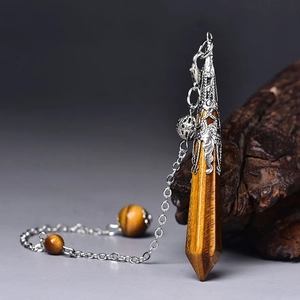 Macro detail of Tiger Eye hexagonal pendant with ornate silver filigree and beads