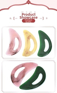 Close-up of ergonomic resin gua sha tools in pink, amber, and green with stone textures