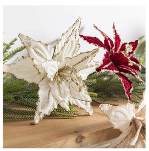 Detailed view of red and white velvet poinsettias with gold glitter on wooden tabletop