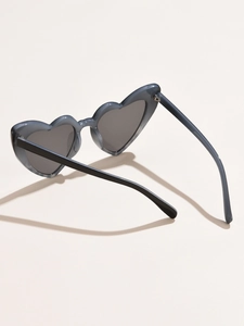 Detail view of heart-shaped sunglasses featuring translucent grey frames and dark lenses