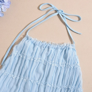 Detail of light blue backless dress with white lace trim and pleated fabric texture