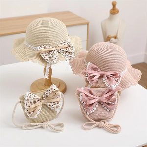 Detail of straw hat and bag set for girls with lace and polka dot bow decorations