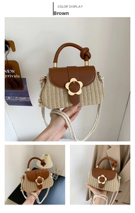 Détail du sac en paille avec rabat en cuir marron et boucle en métal fleur dorée