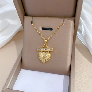 Luxury gold heart pendant necklace with shimmering crystals on white silk background