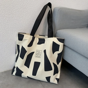 Detail of canvas tote with black and white cow print and Good Student patch