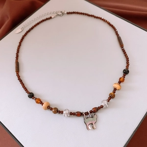 Detail of beaded cat pendant necklace with red glass stones and silver accents