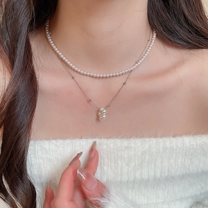 Detail of layered pearl and silver necklace shown on model for a chic vintage look