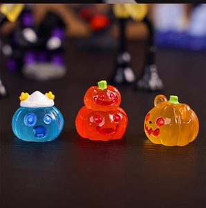 Close-up of translucent resin pumpkin miniatures in red, blue, and orange for Halloween