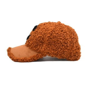 Macro shot of brown lamb wool baseball cap showing teddy fleece texture and suede brim detail