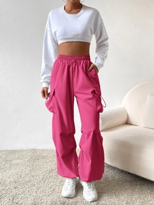 High-waist wide-leg cargo pants in bright pink featuring multiple pockets and drawstring