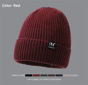 Detail of dark red ribbed knit beanie showing soft texture and logo patch with color options