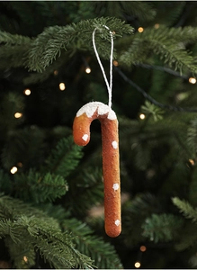 Detail of glittery candy cane ornament hanging on a Christmas tree with warm bokeh lights
