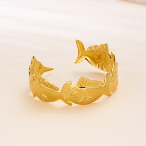 Detailed view of the fish pattern engraving on this gold geometric stainless steel cuff