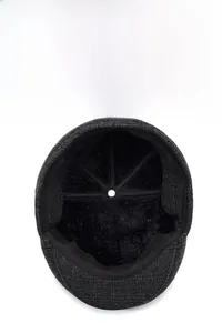 Detailed close-up of thick black plush lining on a dark gray winter newsboy cap