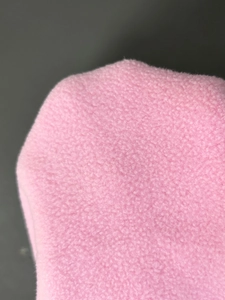 Macro shot of soft pink polar fleece fabric texture showing warmth and material quality