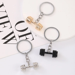 Three metal dumbbell keychains in gold silver and black finishes for fitness enthusiasts