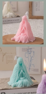 Detail of praying girl scented candles in pink and mint green wax with floral textures