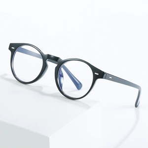 Retro round black anti-blue light glasses with silver stud accents on a geometric stand