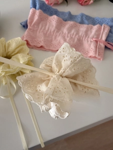 Detailed macro shot of lace floral hair scrunchies with long satin ribbons in macaron colors