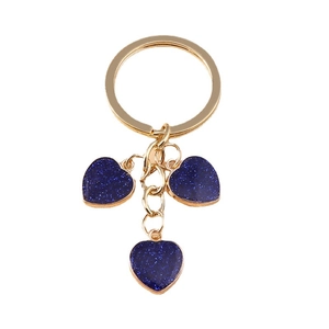 Golden keychain with three dark blue glitter heart pendants on a clean white background