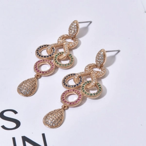 Macro shot of long bohemian tassel earrings with multicolored cubic zirconia in gold setting