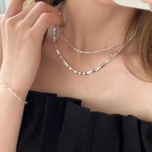 Ensemble collier et bracelet minimaliste en argent avec perles à facettes sur mannequin