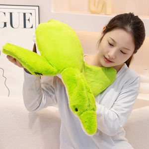 Soft bright green plush pterosaur pillow toy held by a model on a white sofa