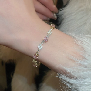 Elegant gold bracelet with pink square stones and white diamonds in S-curve design