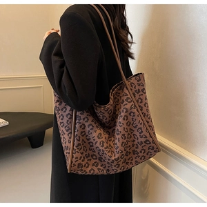 Detail of leopard print tote bag styled with a black coat for a trendy autumn look