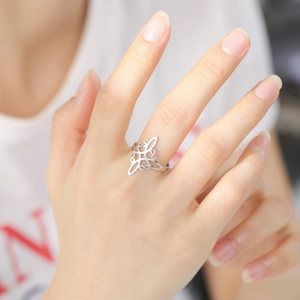 Detailed close-up of a silver Celtic knot stainless steel ring worn on the index finger
