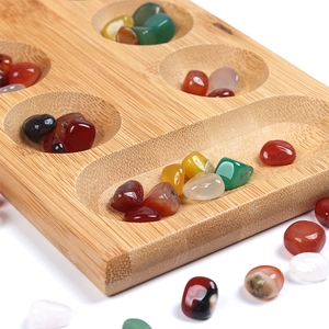 Classic wooden Mancala board game with colorful mineral stones and bamboo texture
