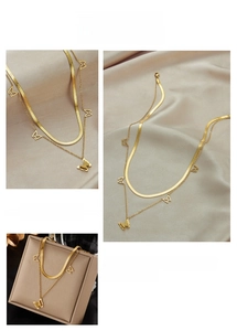 Detail of gold double-layered butterfly necklace with snake chain and cutout charms