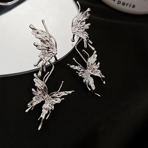 Gros plan du protège-oreille papillon en métal liquide argenté avec des strass brillants