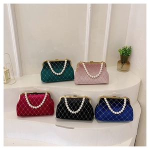 Detail of velvet shell bags featuring quilted texture and elegant pearl top handles