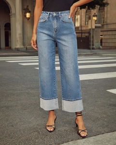 Street style shot of high-waist blue stretch jeans featuring wide cuffed hems