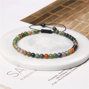 Close-up of 4mm natural stone beads on a black adjustable woven cord yoga bracelet