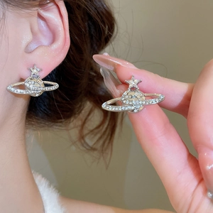Close-up of sparkling silver Saturn star stud earrings with cubic zirconia on model