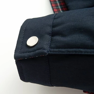 Detail der Jackenmanschette mit Silberknopf und Retro-Karofutter aus Twill-Gewebe