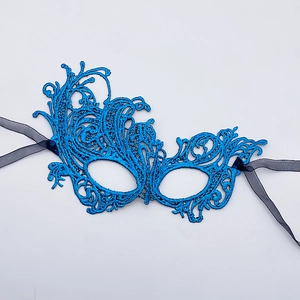 Macro shot of blue lace phoenix masquerade mask with intricate embroidery and silk straps