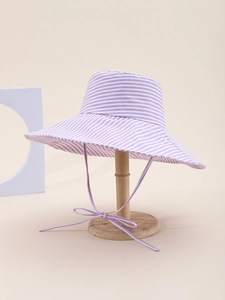 Detail of a purple striped sun hat with a wide brim and adjustable bow tie strap