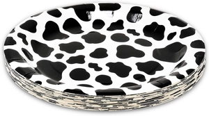 Stack of disposable paper plates with black and white cow print for party decoration