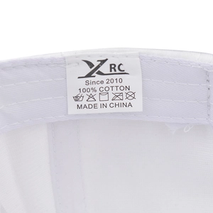 Detailed close-up of 100% cotton label and stitching on white embroidered bear baseball cap