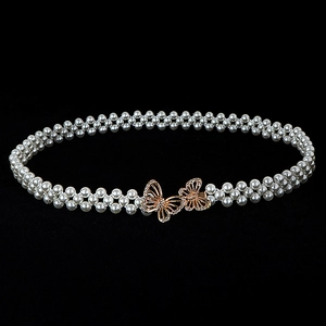 Detailed close-up of woven white pearl belt with rose gold hollow butterfly buckle